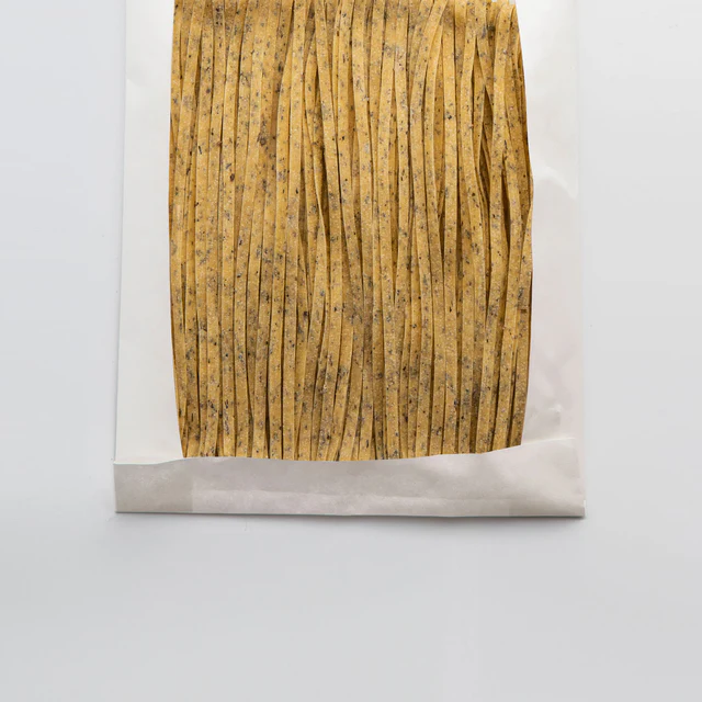 Ambachtelijke fettuccine met basilicum uit Campofilone. Gemaakt met verse eieren en aromatisch kruid. Perfect voor frisse sauzen.